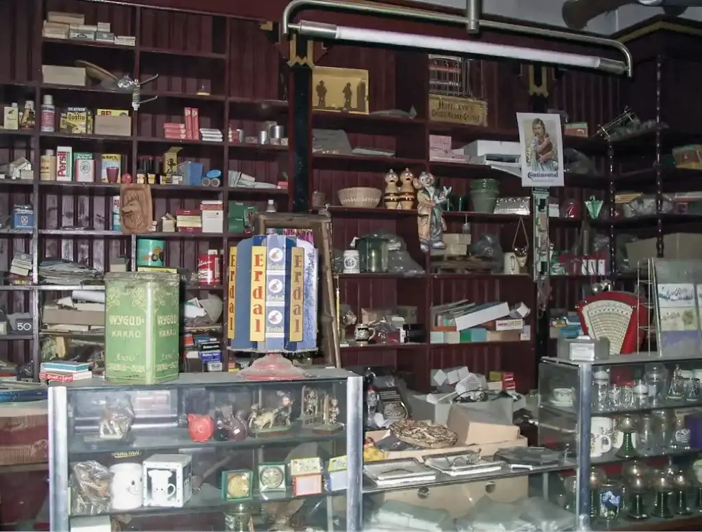 Innenaufnahme des Kaufhauses mit überfüllten Regalen voller alter Waren und Sammlerstücke.